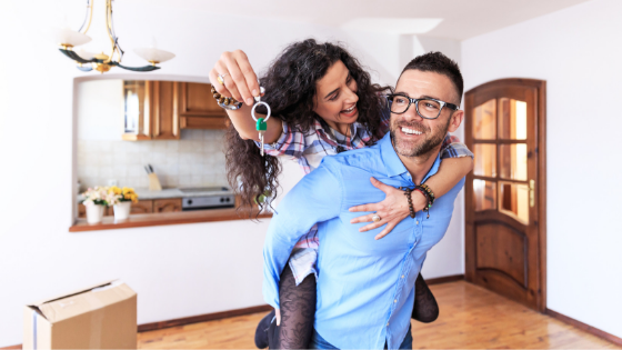 young couple holding keys to new home