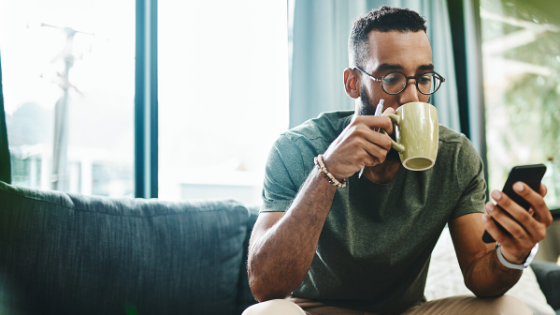 Man drinking coffee and looking at his phone