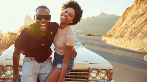 Young couple in front of car