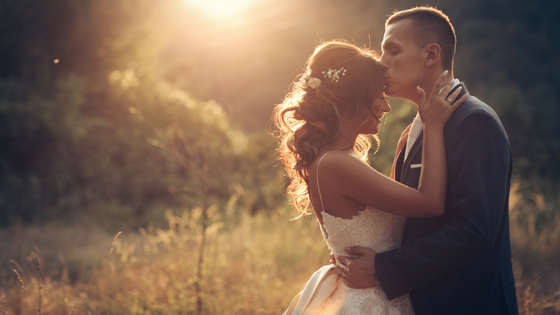 Groom kissing bride on the forehead