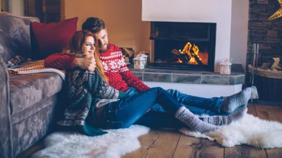 Young couple sitting by a fireplace